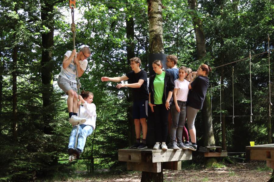 Gruppe von jungen Menschen beim Klettern im Wald