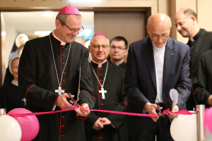 Das Bild zeigt die feierliche Einweihung des renovierten Multimedia- und Presseraums der Polnischen Bischofskonferenz. Im Vordergrund schneiden Erzbischof Tadeusz Wojda SAC (links) und Prof. Dr. Thomas Schwartz (rechts), Hauptgeschäftsführer von Renovabis, ein rosa Band durch.