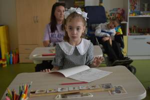 Ein kleines Mädchen mit weißer Schleife im Haar am ersten Schultag im Klassenzentrum in Gomel in Belasus