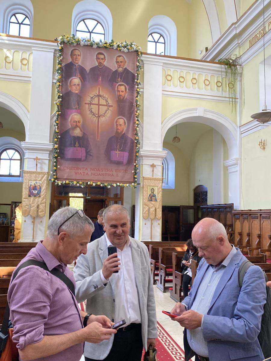 In der Kleinstadt Blaj, Sitz der griechisch-katholischen Erzdiözese Alba-Iulia-Făgăras, zeigte Claudiu Nicusan, Mitarbeiter der Erzdiözese (Mitte), die Kathedrale. Im Hintergrund zu sehen: Die sieben Märtrerbischöfe aus der Zeit der Kirchenverfolgun unter dem Ceaușescu-Regime.
Die in den Jahren ihrer Inhaftierung (1950-1970) in Haft verstorbenen Glaubenszeugen wurden 2019 im Vorfeld des Besuchs von Papst Franziskus in Rumänien seliggesprochen.