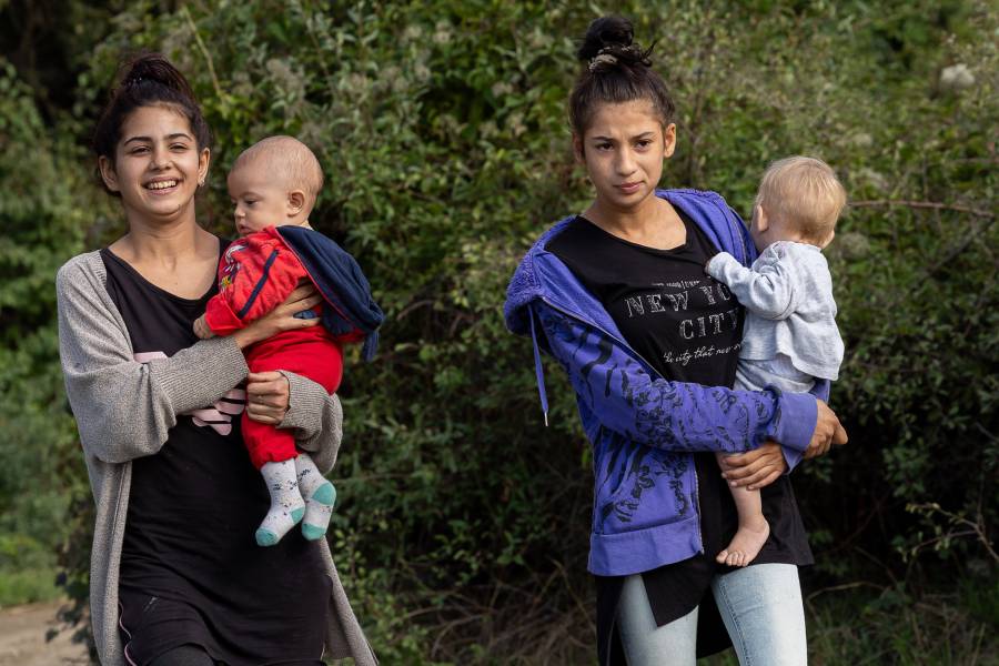 Zwei junge Frauen laufen mit ihren Kleinkindern durch die Roma-Siedlung in Malki Iskar